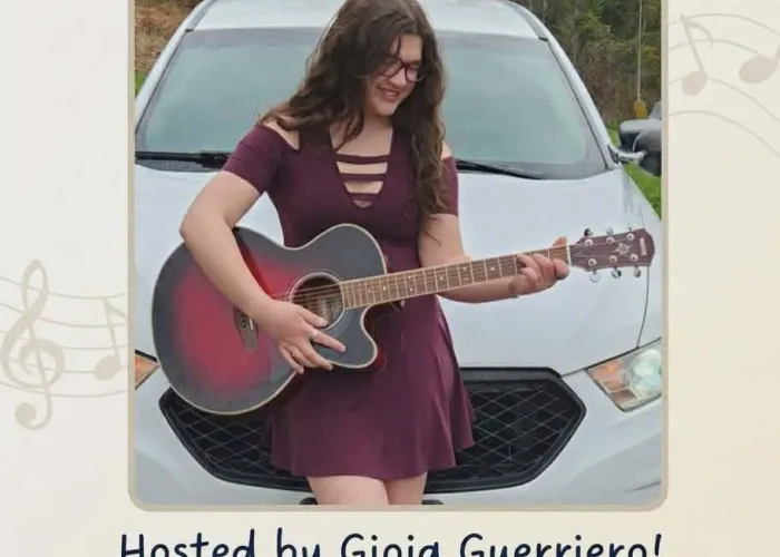 Gioia Guerriero holding acoustic guitar in front of white car, event details